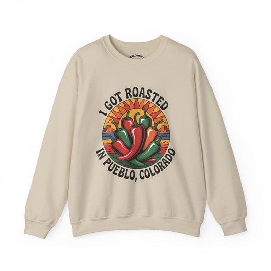 Beige sweatshirt with Pueblo roasted chilis graphic and “I Got Roasted in Pueblo, Colorado” text on white background